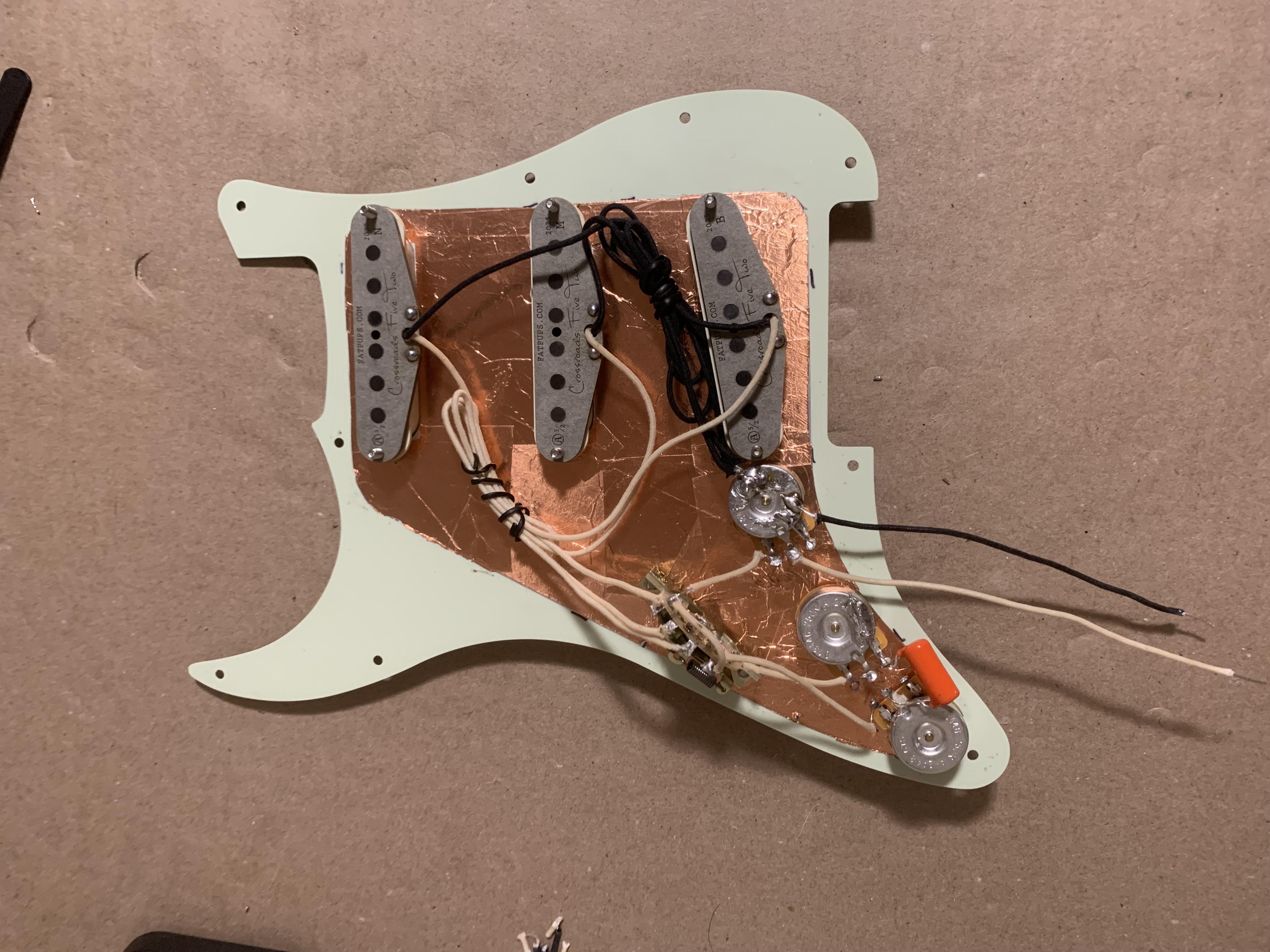 Guitar with the pickguard off and electronics exposed