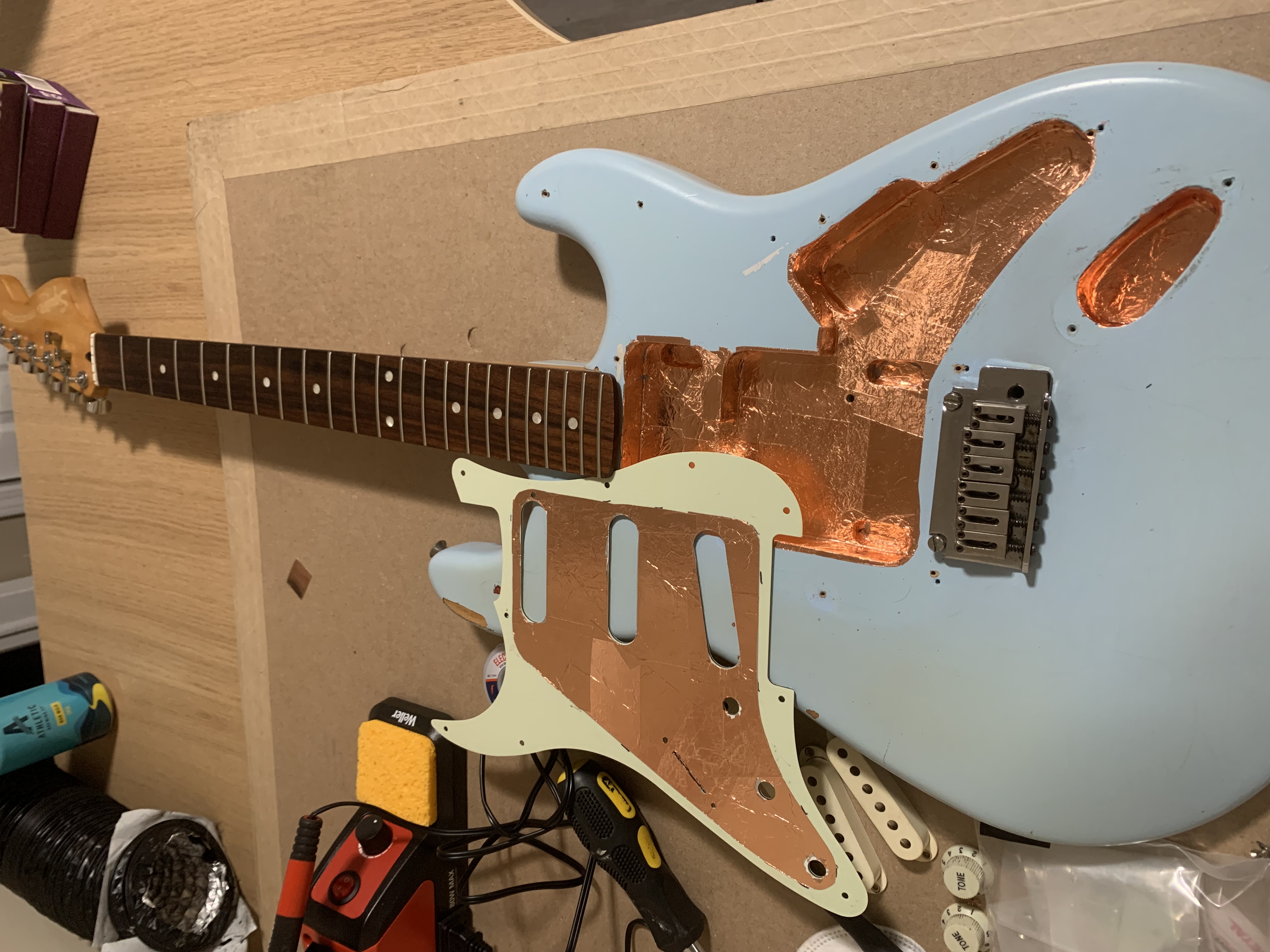 A slightly dismantled guitar on a workbench