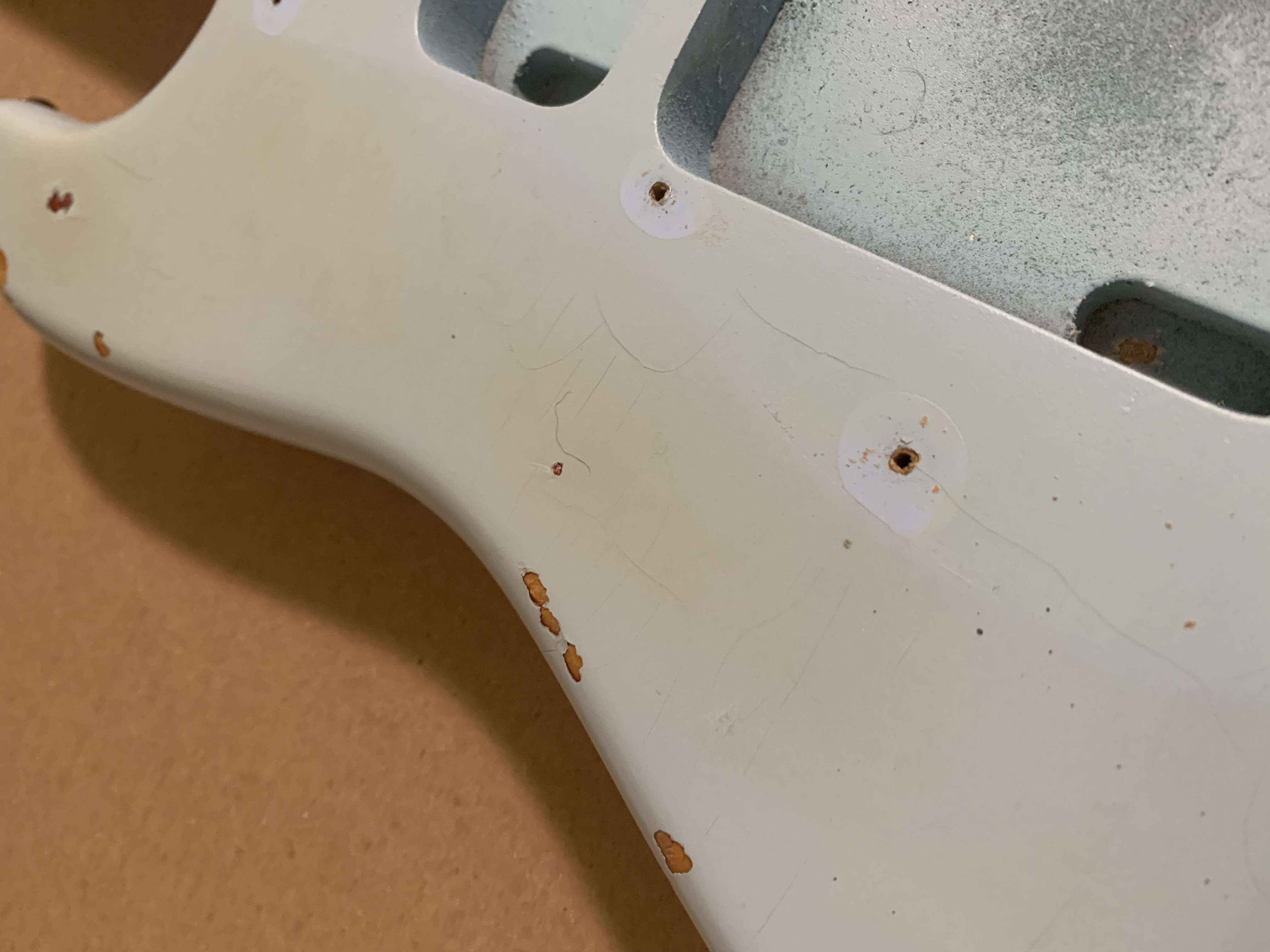 A slightly dismantled guitar on a workbench