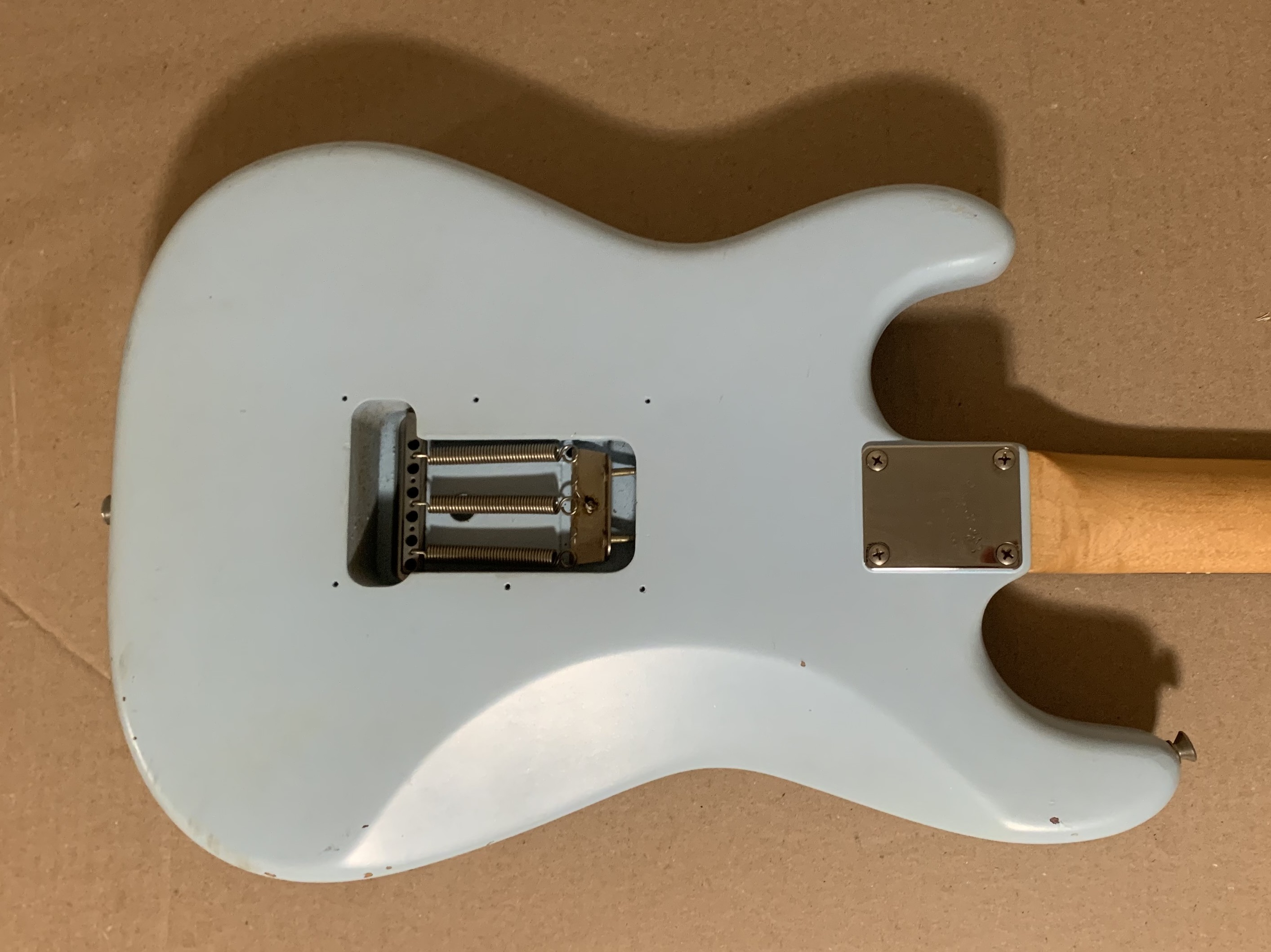 A slightly dismantled guitar on a workbench