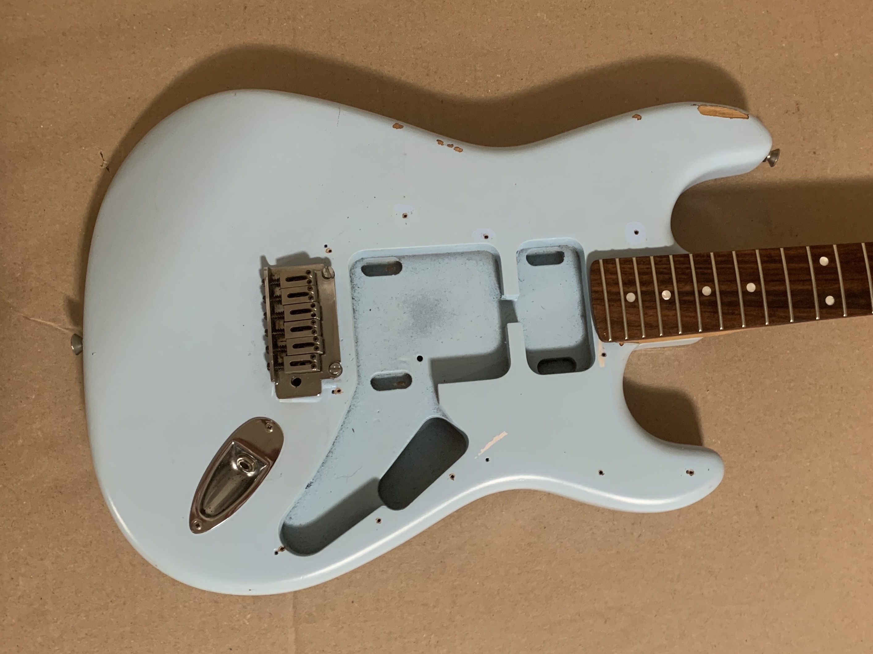 A slightly dismantled guitar on a workbench