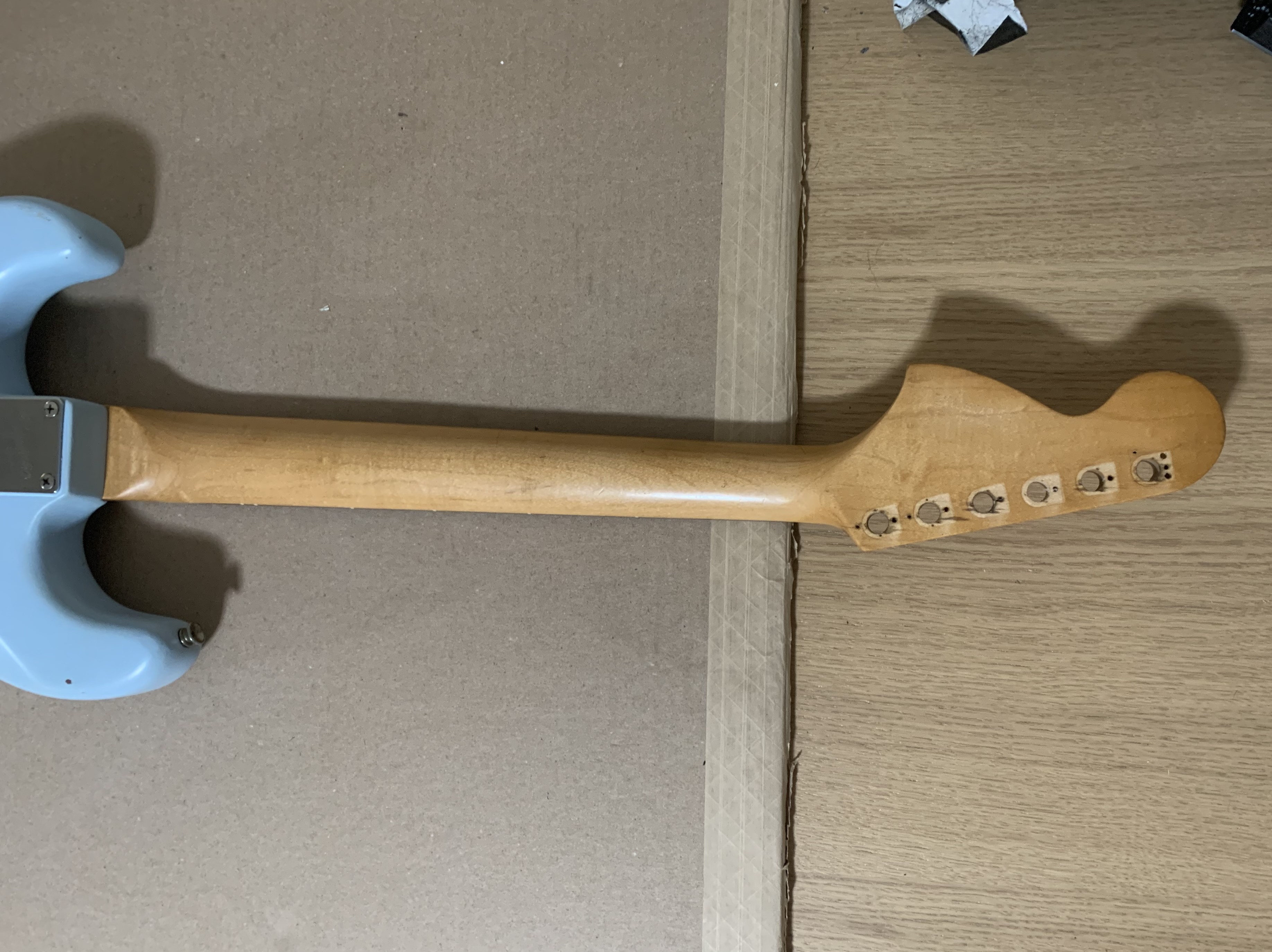 A slightly dismantled guitar on a workbench