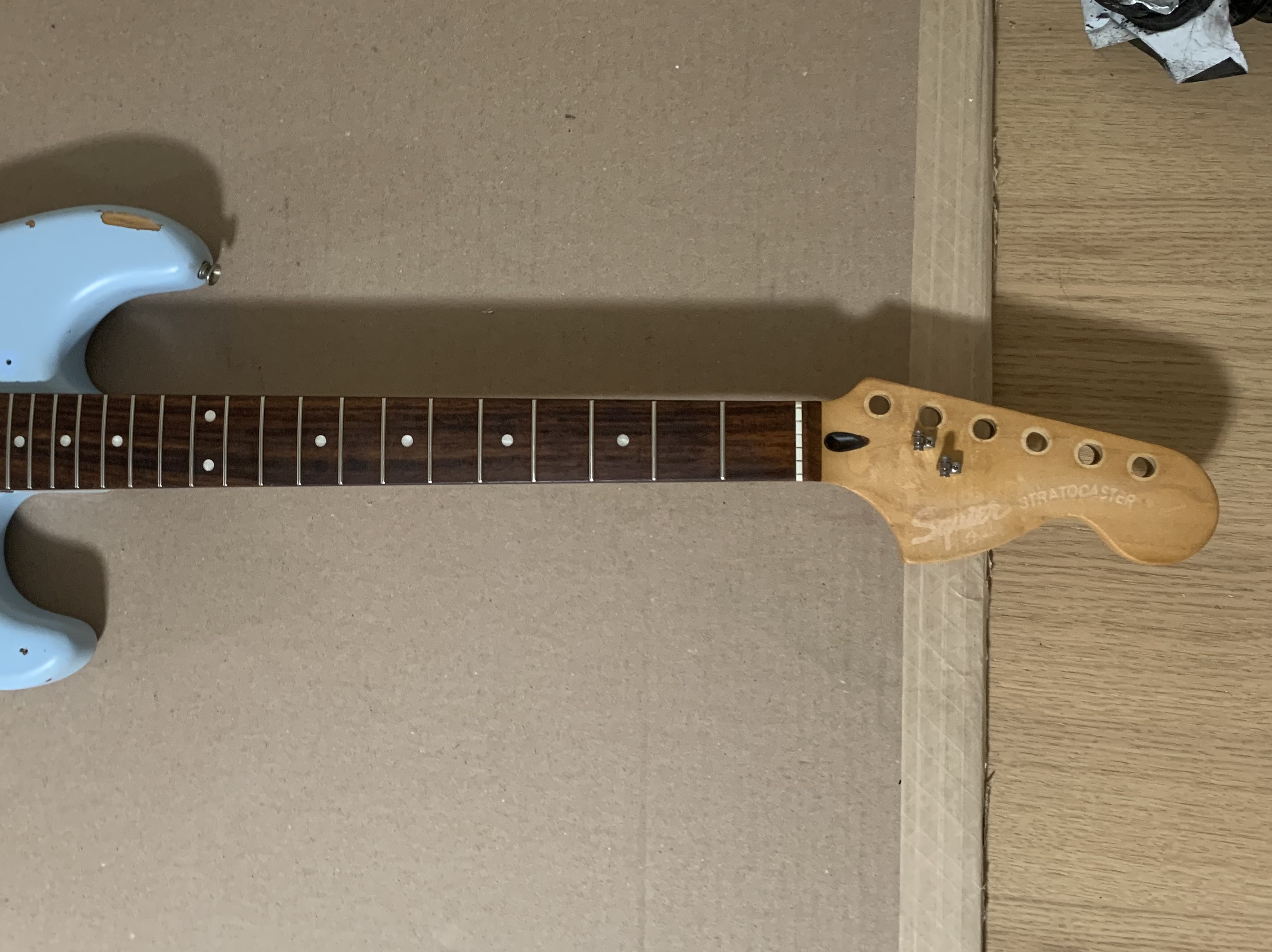 A slightly dismantled guitar on a workbench